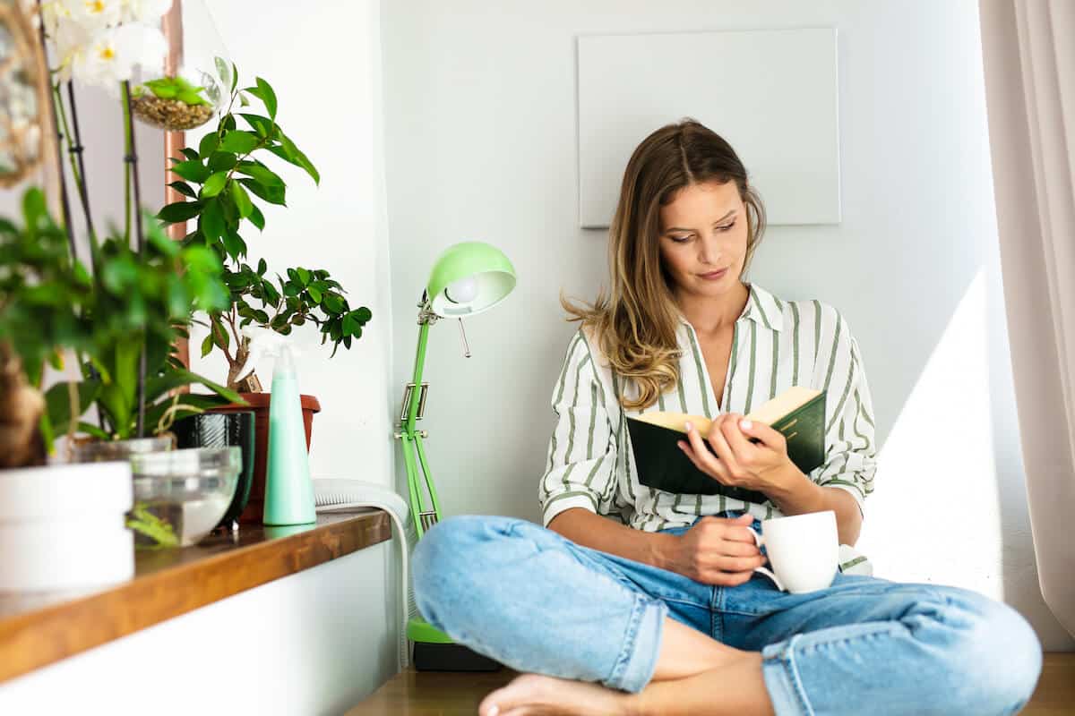 woman spending time alone reading a book at home.