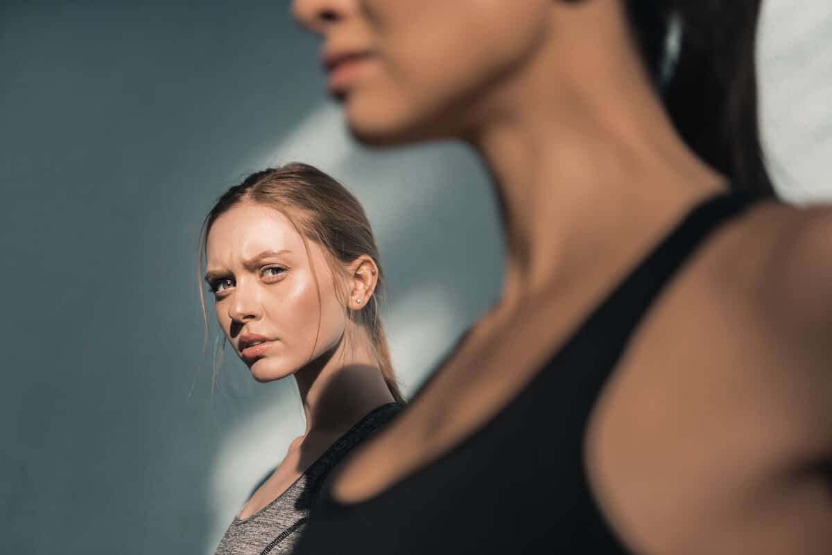 woman at gym looking at fit woman with envy.