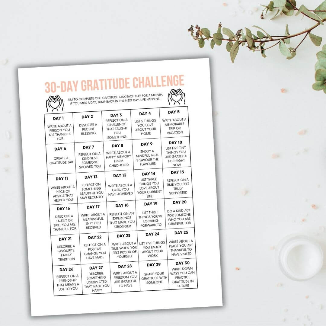 free printable 30 day gratitude challenge on desk with tree sprig.