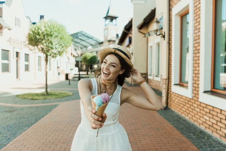 happy woman living her best life, walking along the street with an ice cream in hand.