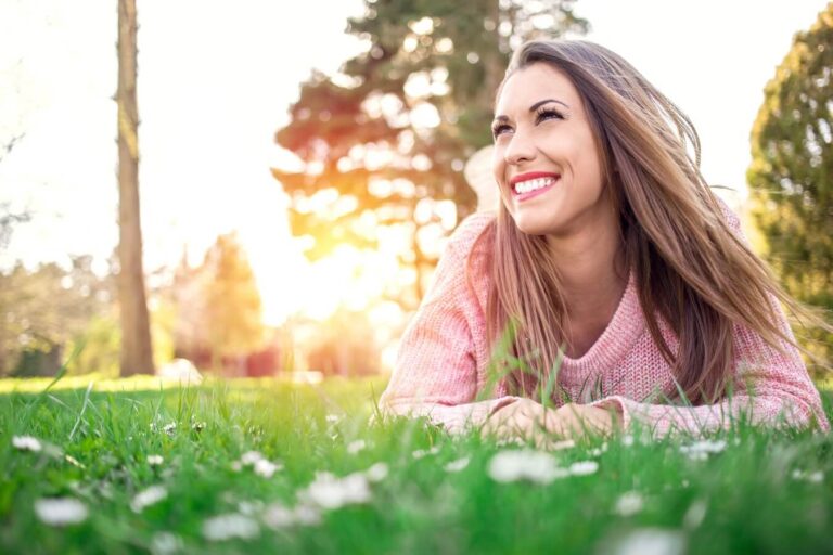 woman with pink sweater enjoying time alone outdoors.