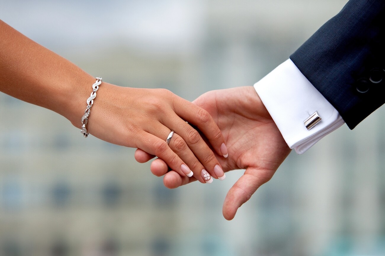 man and woman holding hands on wedding day.