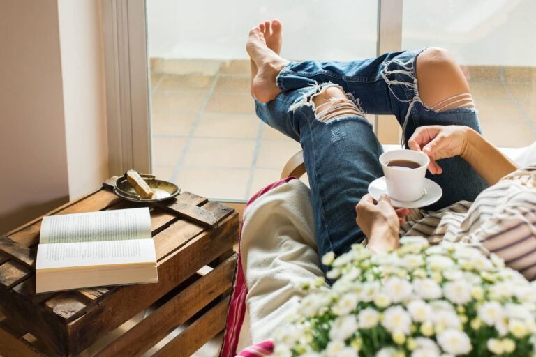 woman relaxing in a chair with a cup of coffee during me time.