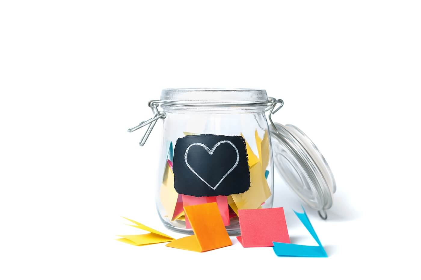 glass jar with coloured notes folded inside.